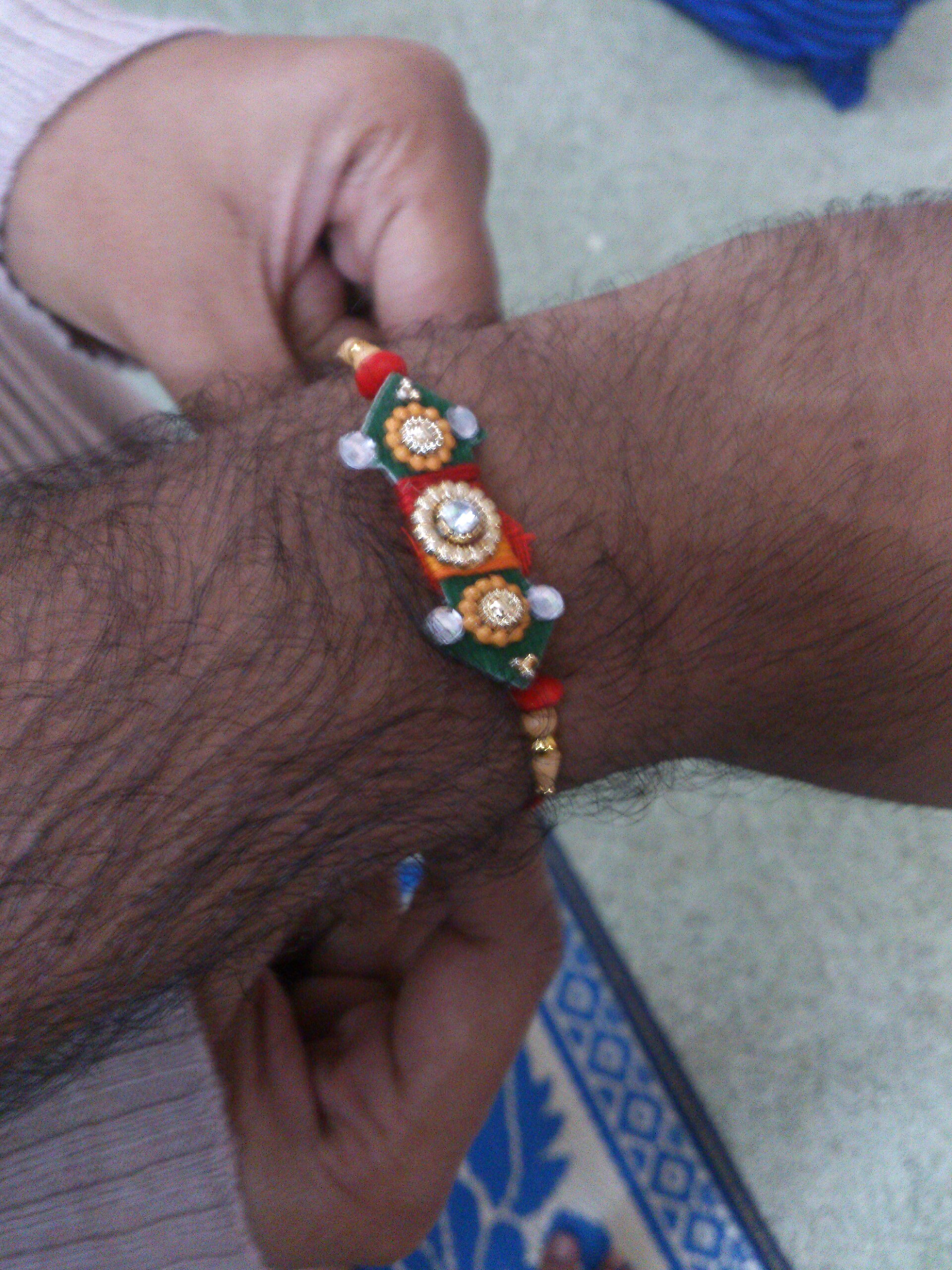A sister tying rakhi thread on the wrist of a brother on Hindu festival of Raksha Bandhan