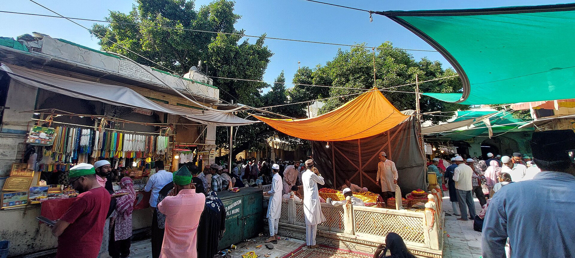 A vibrant outdoor market scene in Rajasthan shows people browsing colorful stalls, reflecting Indian culture.